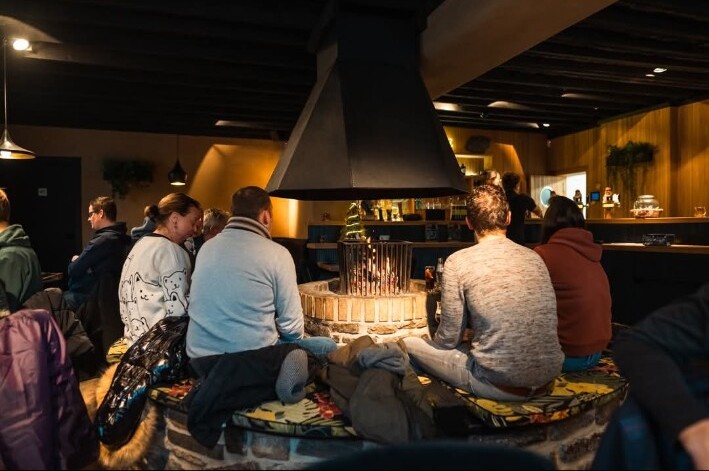 Salle chaleureuse de la Taverne avec son feu central